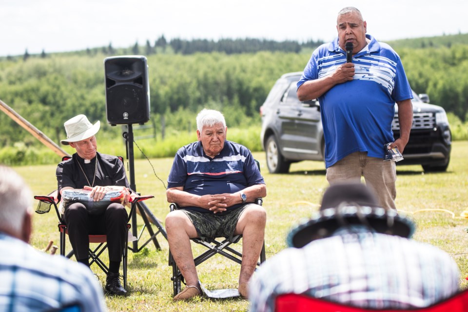 Bishop Gary Franken of the Diocese of St. Paul (left) and Frank Large listen as Saddle Lake Chief Jason Whiskeyjack makes a speech.