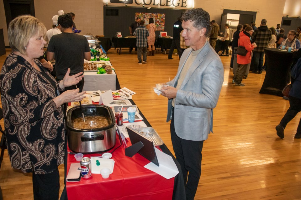 Carrie Froehler talks to a community member about her Norweigan dish.