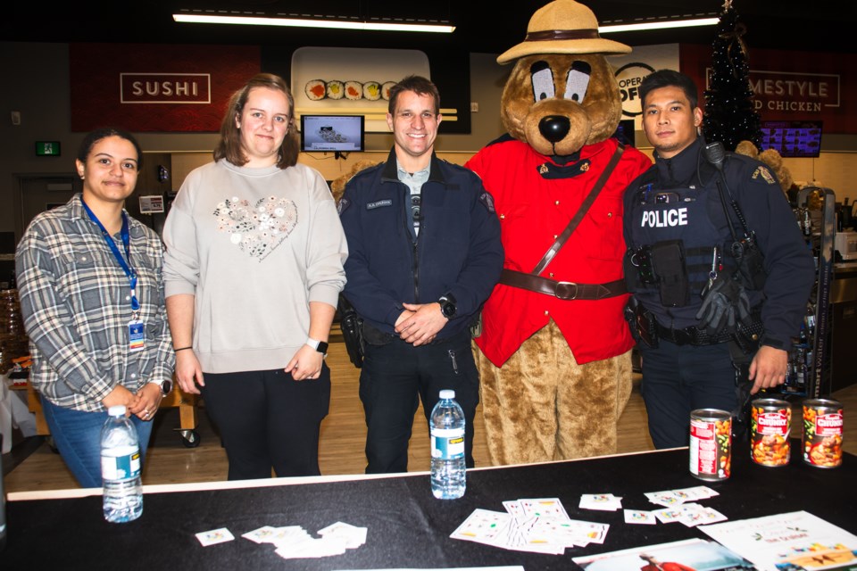 From left to right are Kiara Gamble with Victims Services, public information officer Kellieka Formanek, S/Sgt. Andrew Druhan, Safety Bear, and Cst. Mark Agustin at the Cornerstone Co-op during the Cram the Cruiser event on Dec. 13.