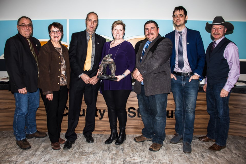 Sheila Kitz (middle) was presented with the "Mother Bear" sculpture by the County of St. Paul council on Feb. 13 as a symbol of their appreciation for 14 years as the County's Chief Administrative Officer. Kitz recently retired from the position. From left to right are councillors Darrell Younghans, Maxine Fodness, Reeve Glen Ockerman, Dale Hedrick, Ross Krekoski, and Kevin Wirsta.