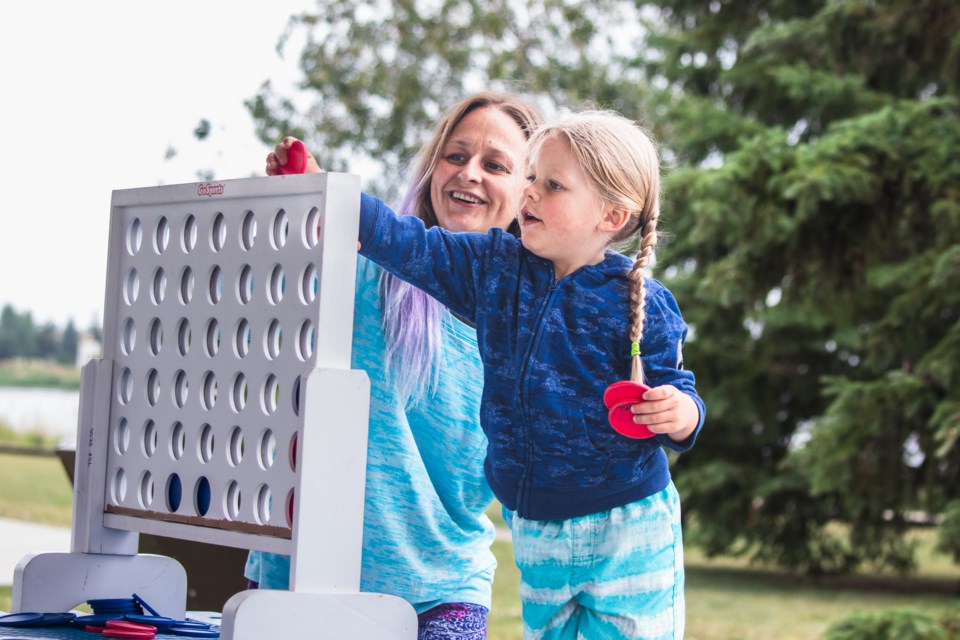 Cara Krekoski teaches her son how to play Connect Four.