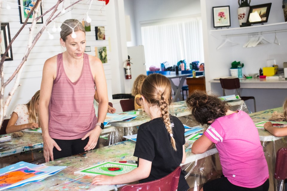 Pam Bohn (left), art instructor, guides a young artist. | Mario Cabradilla