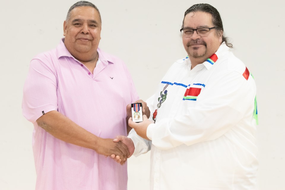 Saddle Lake Chief Jason Whiskeyjack (left) presents the King Charles III Coronation Medal to Stacey Harrison on March 17.