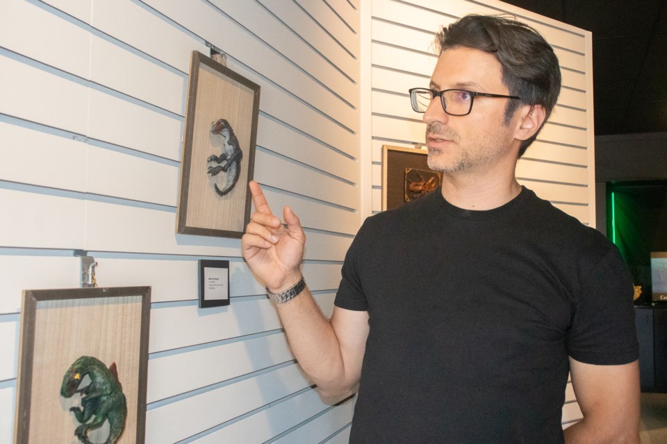 Eric Spoeth talks about the dinosaur sculpture that his son, Leo, created and showcased at the paleontology-themed art exhibit held at the St. Paul and District Art Foundation.