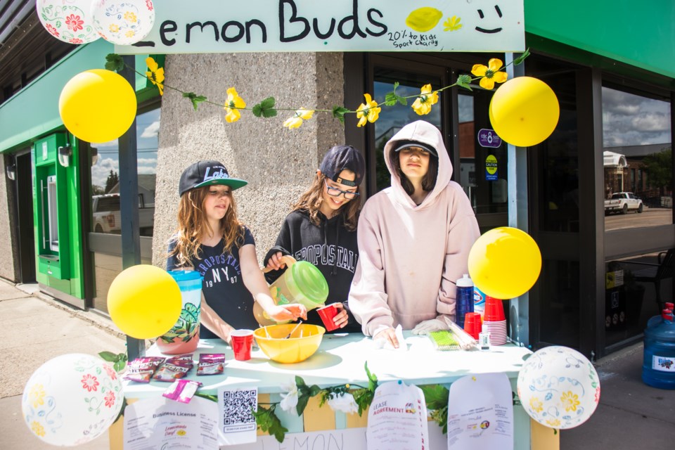 From left to right are Ava, Aliana, and Zalika, having some fun making lemonade while learning about doing business.