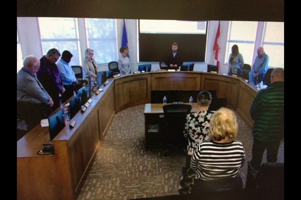 Council members and people in the council gallery stand for a moment of silence at the start of Tuesday's Lac La Biche County council meeting at McArthur Place.