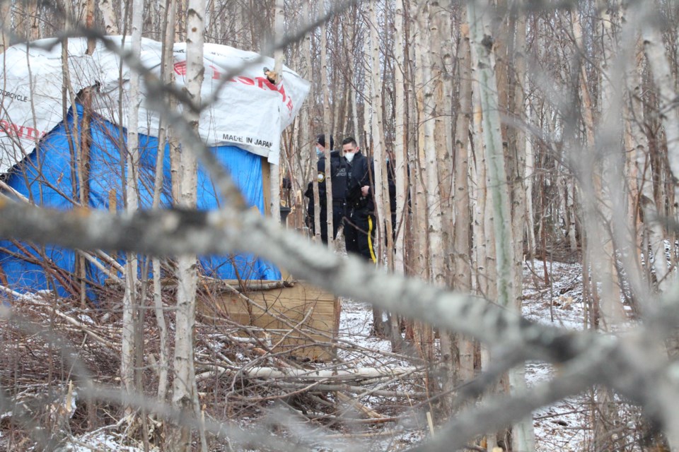 A Lac La Biche RCMP constable looks across the camp area as police and peace officers discussed the removal and tear-down plan with community advocates and camp leaders.