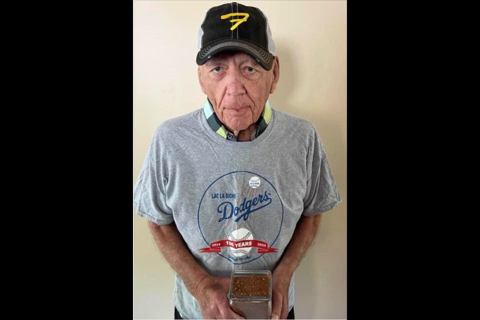 Lloyd Fleming wearing a souvenir Dodgers shirt and holding a container of Diamond One shale. Some area residents are frustrated that the long history of the community's baseball diamonds has been erased without any thought.