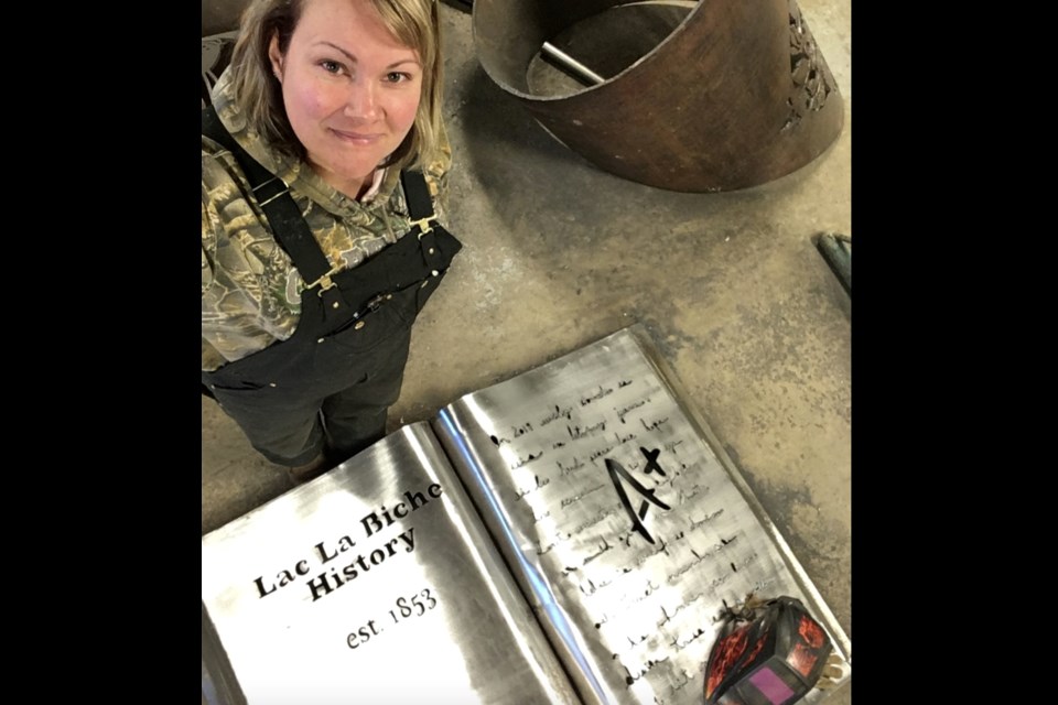Melanie Braund with one of the pieces of the massive metal display that now greets visitors at Lac La Biche's Bold Center.