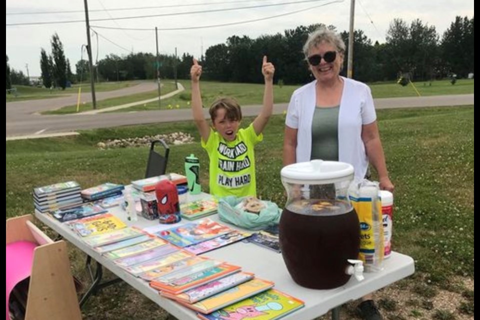 Lac La Biche youngster Mitchell Lyttle and his grandma Adrienne Creighton at his book, baking and iced tea stand along 99 Avenue. 