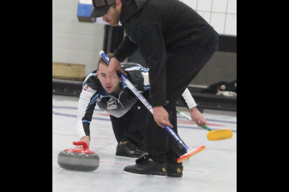 Corey Leach slides out with a shot as his brother Cody prepares to sweep. The Leach rink won the weekend's mixed bonspiel.