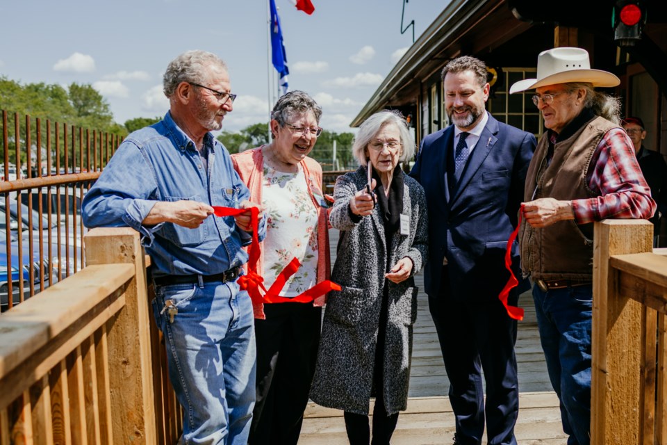 Museum representatives Clem Fontaine, Alice Bourget, Yolande Kitt, MLA Scott Cry, and Andy Pomerleau take part in a ribbon cutting ceremony at the new train station, located at the St. Paul Museum.