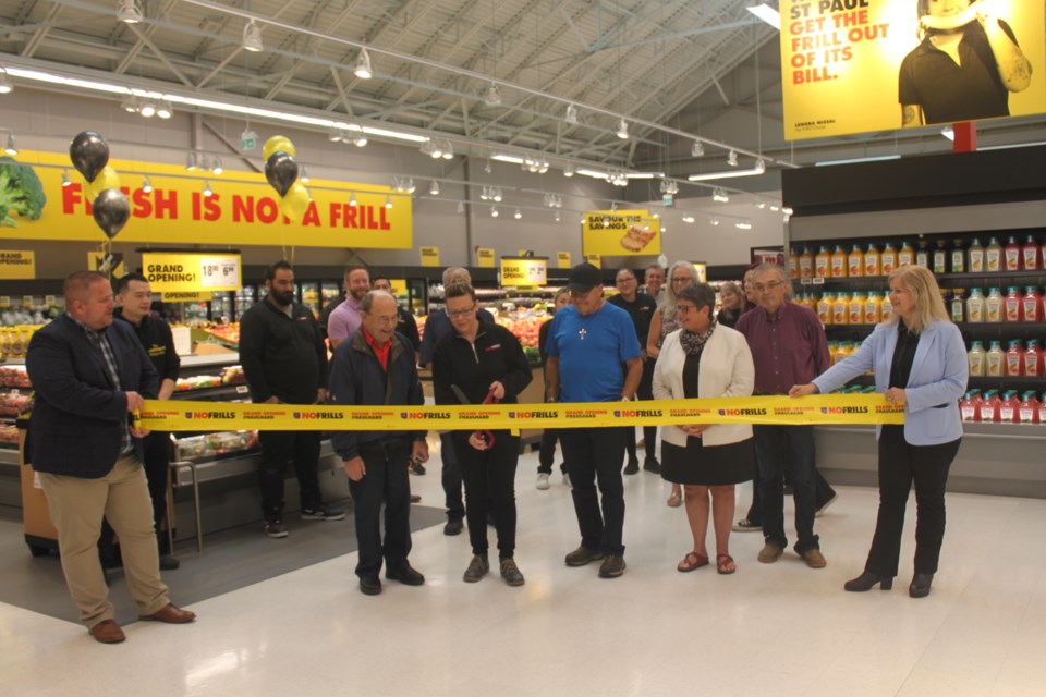 No Frills owner Lenora Missal cuts the ribbon to open her new St. Paul outlet. She is joined by (left to right) Ryan Davis, No Frills vice-president operations western Canada, grandfather Micheal Zacharko, father Roy Missal, Mayor Maureen Miller, Bernie Poitras, Métis Nation District 12 captain, and No Frills district manager Serena Paron.