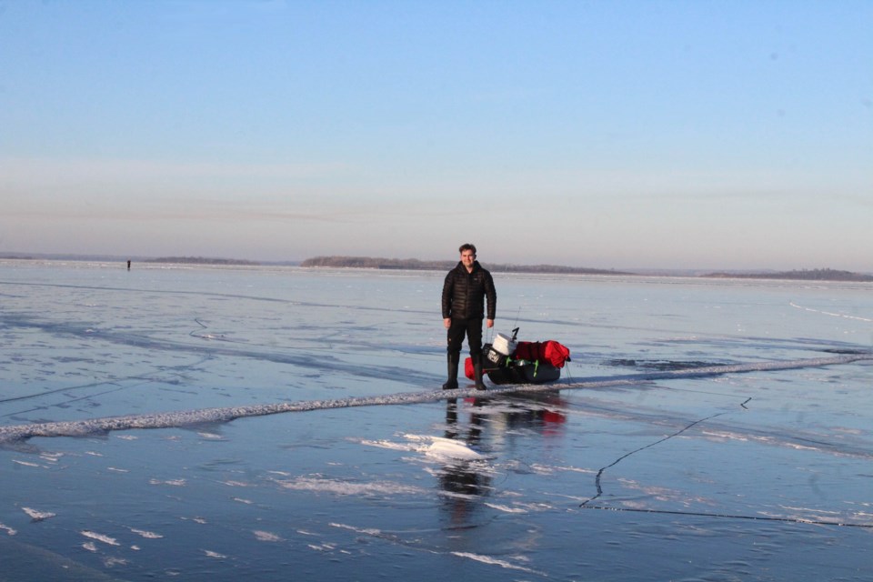Ice to the horizon. Peter Benson stands on the clear ice of Lac La Biche Lake on a December afternoon of ice fishing. Almost no snow so far in the season has created ice surfaces that are frozen smooth.