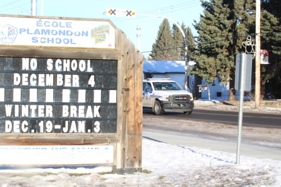 Lights flashing, an Alberta Sheriffs truck chases down a truck and trailer that rolled through the main street speed zone at Ecole Plamondon last Friday afternoon.   Image Rob McKinley
