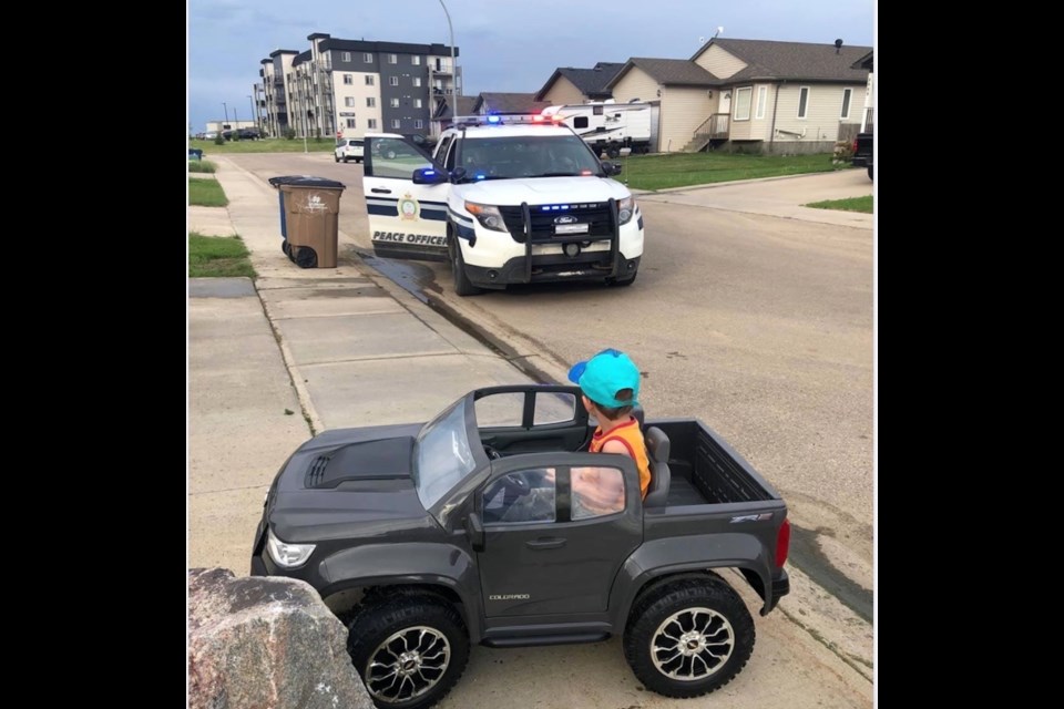 Four year old Michael Shalapay watches as Lac La Biche County peace officers arrive to make sure his fender bender with a driveway rock isn't too serious.           Image: Keith Shalapay