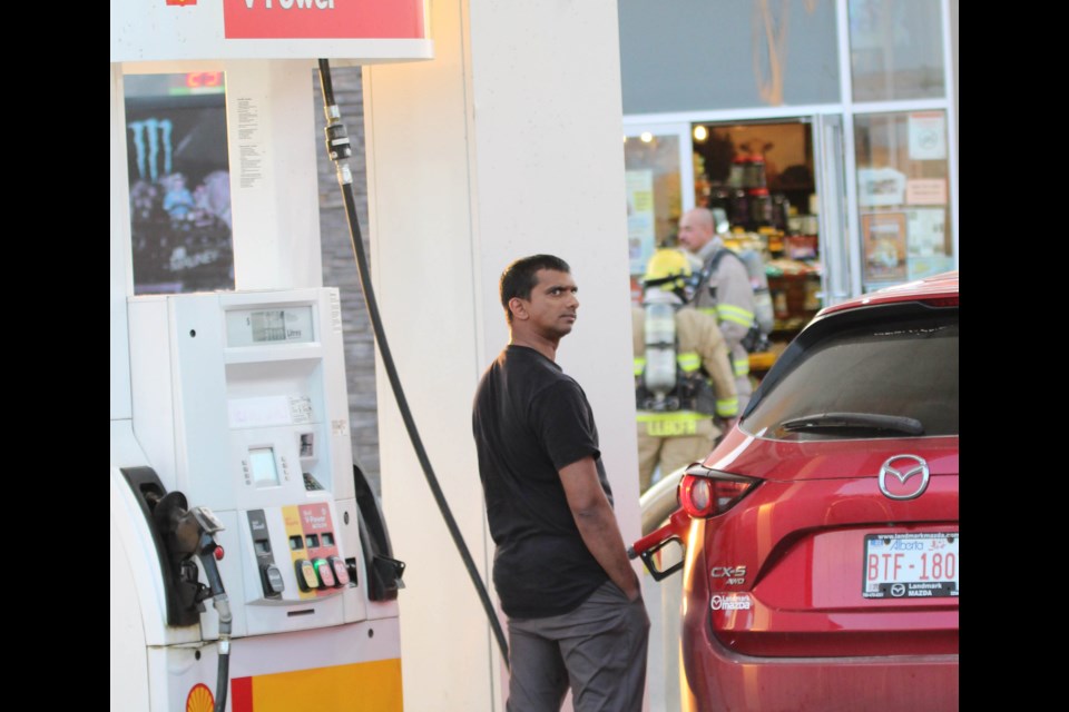 As firefighters in full bunker gear prepare to investigate a fire call at a Lac La Biche gas station, customers continued to fuel up their vehicles, watching the activity.
