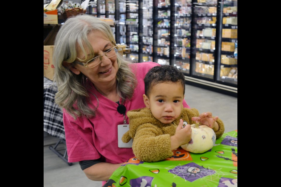 Furry-suited little pumpkin decorator Dominic LeBlanc showed off his colorful project with some help from Elk Point Cornerstone Co-op staff member Buffy.