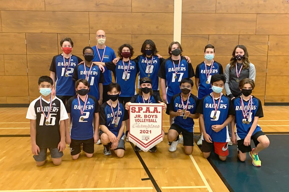 The Racette boys volleyball team is pictured with the 2021 SPAA banner.