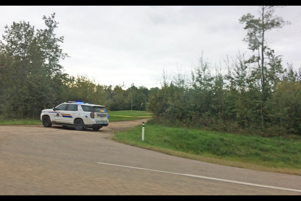 An RCMP vehicle sits at a property entrance along Highway 36 near Lac La Biche on Sept. 4 where the body of a 22 year old man was found.   RCMP have now arrested and charged a 29 year old man with second degree murder.