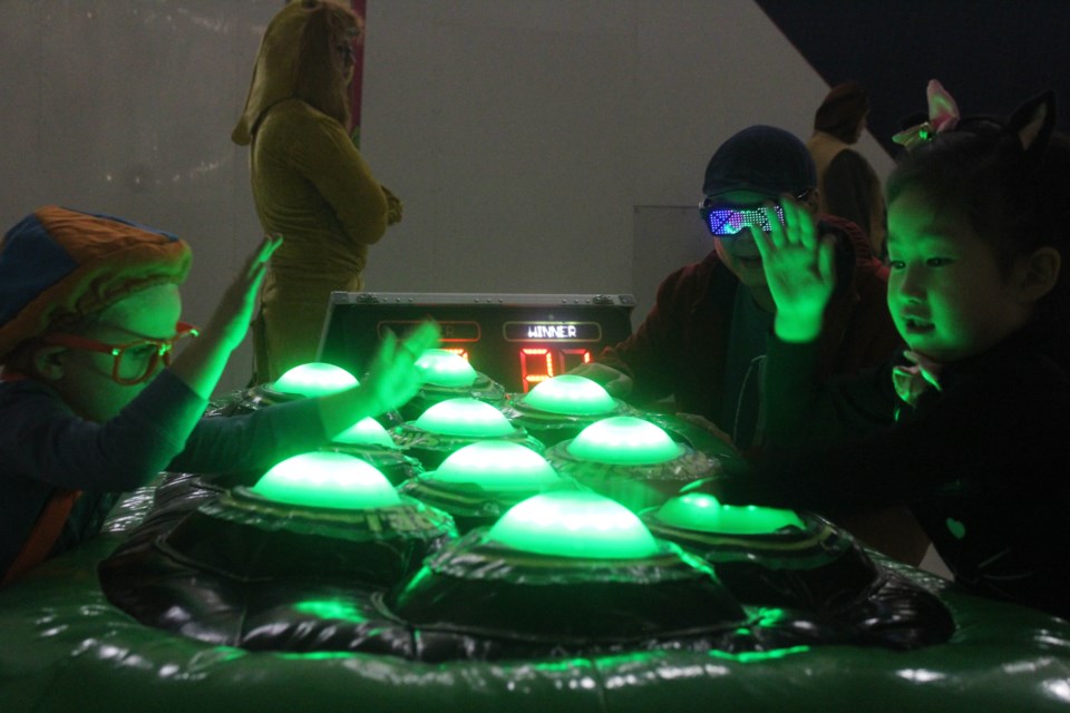Reid Beniuk (left) enjoys a light-up wack-a-spooky-eyeball game with some new friends during the Spooktacular event.