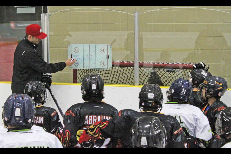 Gord Bell shows players how the next drill is going to roll out. Bell ran a week-long hockey camp for young skaters last week at the Bold Center.