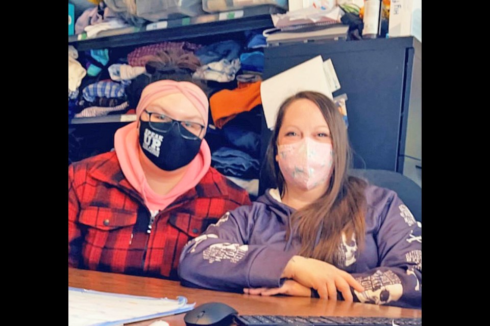 Lakeland Out of the Elements Shelter executive director Skylar Harpe and shelter coordinator Amy Cadieux sit near shelves of blankets and clothing that have been donated to the shelter in recent weeks.       Submitted