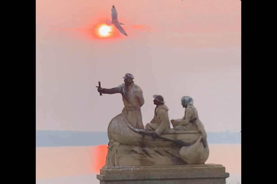 A shorebird flies over the David Thompson statue on the shores of Lac La Biche lake. Two water advisories have been issued in the last week about the lake's water quality.