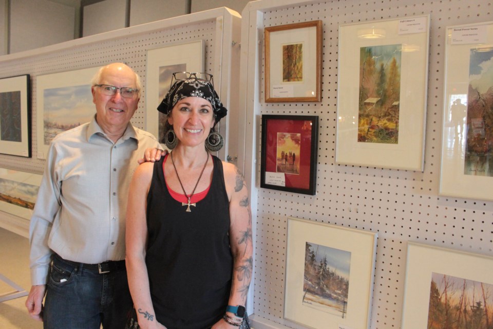 Andre Piquette and Sue Lapierre at last Friday's Lac La Biche Farmers' market where Louise's work has been for sale. Proceeds from the sale will go to a unique bursary for young Francophone art students.    