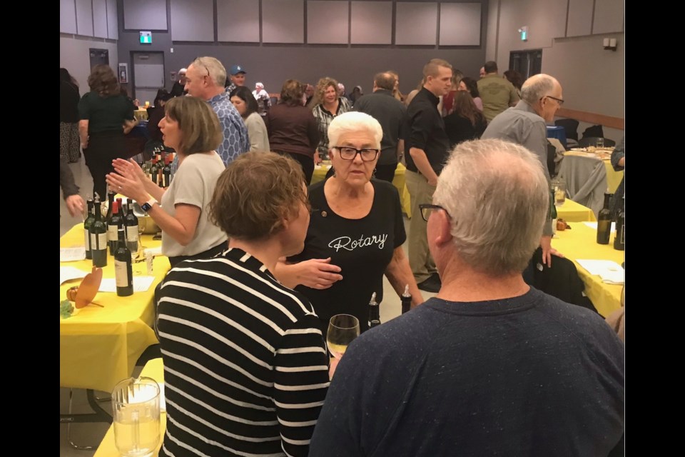 Lac La Biche Rotary Club's Sue Ward explains the night's Italian selection of wines to some of the guests