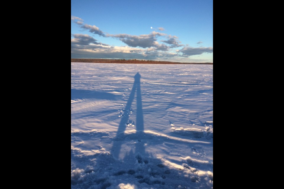 Long shadow legs as the sharp angle of one of winter's last sunsets shines onto Beaver Lake.