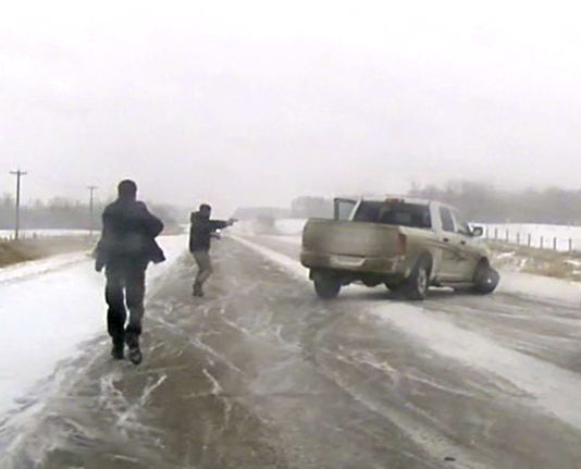 RCMP approach a disabled truck on Highway 55 near La Corey on Wednesday morning. A suspect ran from the vehicle and was found in a nearby garden shed. 