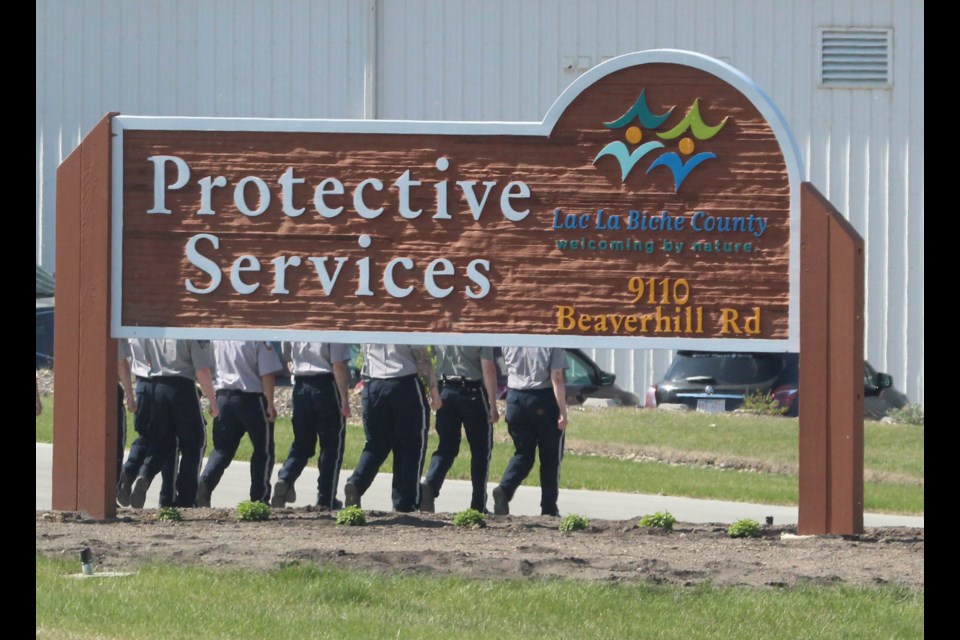 So that's how they move the sign. 
 The legs and bodies of these Peace Officer training recruits seen on a recent marching drill at the Lac La Biche County Protective Services building are attached to the smiling faces of recruits who will be graduating today (June 1) from the 11-week program offered in Lac La Biche. The Law  Enforcement Training program began in 2020. The program trains a full peace officer course as well as individual module training for existing law enforcement members. The unique program has graduated more than 50 new peace officers and hosted more than 300 participants for individual course training.