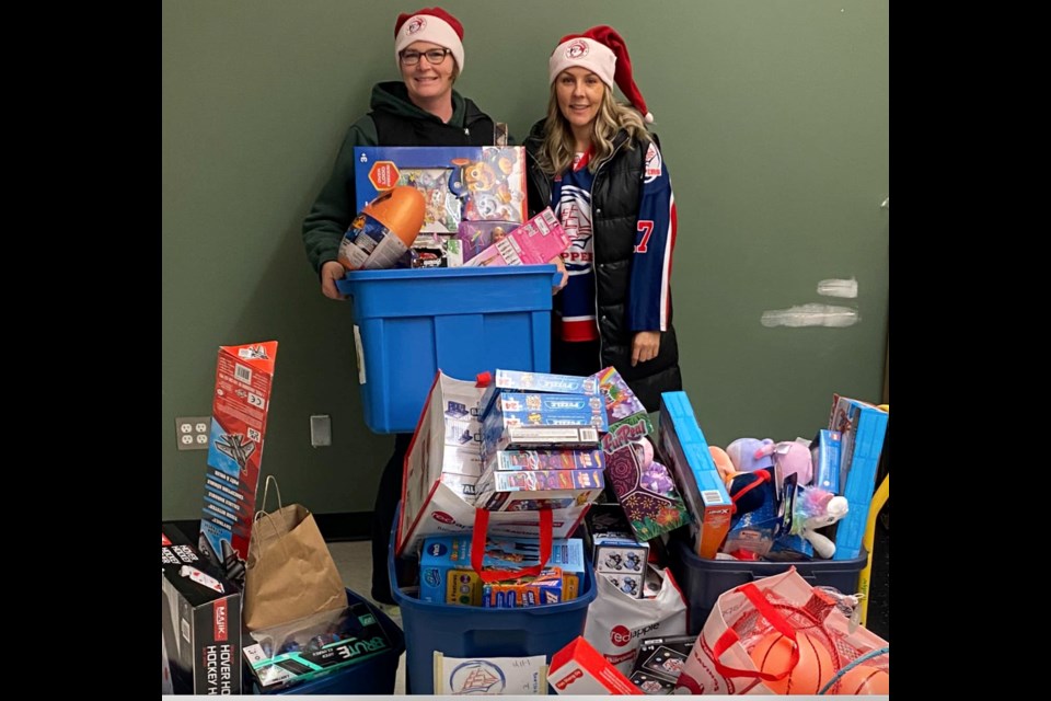 Natasha Downes from the Lac La Biche Firefighters' Society and U11 Clippers hockey mom Christine Tredger show off the mountain of toys collected at the recent U11 hockey tournament at the Bold Center.