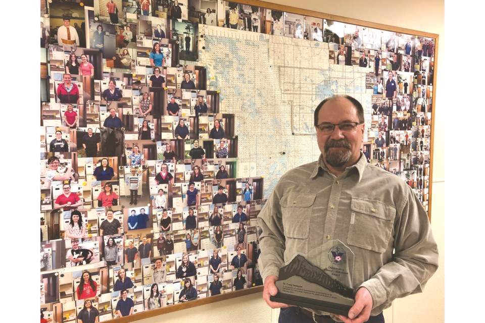 Dr. Craig Hellquist stands in front of the St. Paul Veterinary Clinic’s ‘Wall of Fame’ featuring the many young people who have spent time at the clinic through the years learning about the veterinary profession. He was officially named as the recipient of the Outstanding Mentor Award by the Alberta Veterinary Medical Association on Saturday. / Photo supplied