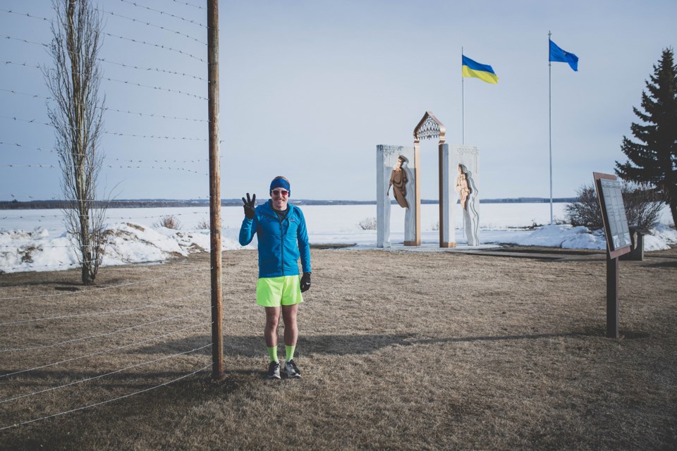 Daylan Wizniuk stands in front of two monuments at St. Paul's Lagasse Park on Saturday evening, ahead of starting his third marathon in one day. 