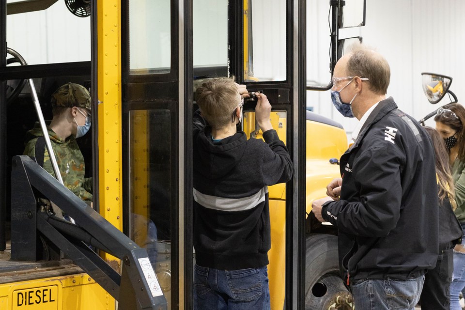 New Myrnam School teacher Robert Tymofichuk works with students on a project to convert a school bus into a tiny home.
