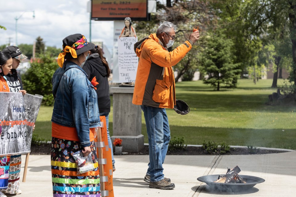 Tobacco ties were placed into a fire, in honour of the 215 children found in unmarked graves in Kamloops.