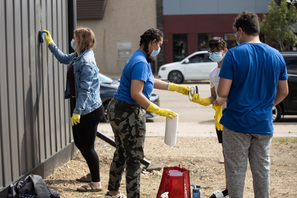 Youth and other community members clean up graffiti on July 22. Janice Huser photo.