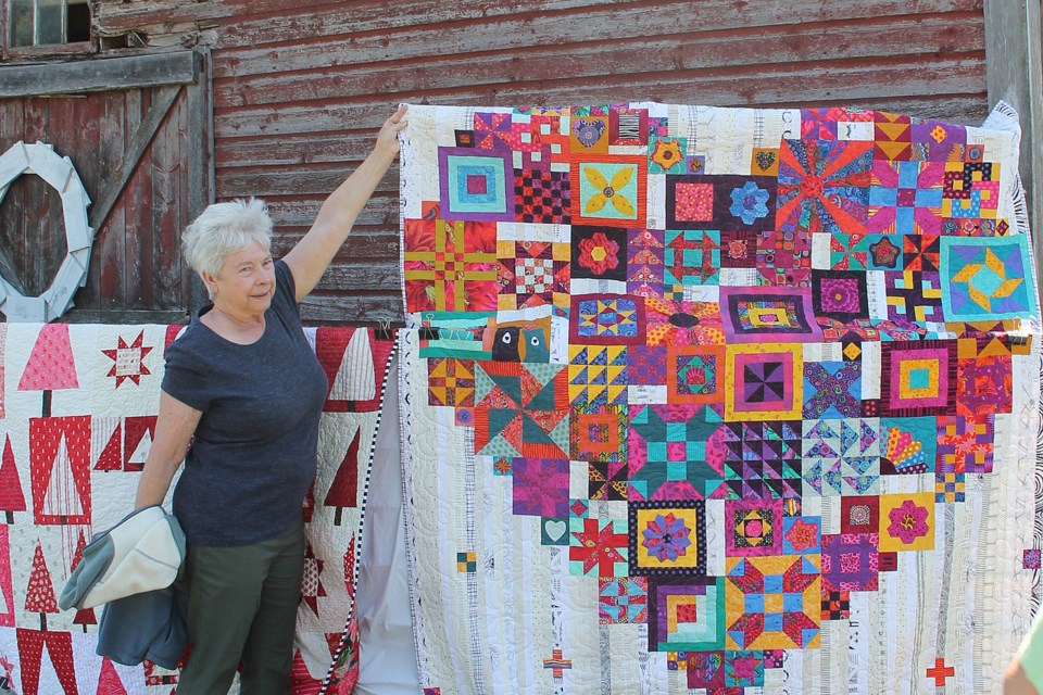 Doris Wilson holds up a corner to help display an outstanding fabric art ‘Boho Heart’ quilt created by Janice Pritchard and inspired by an Australian designer.