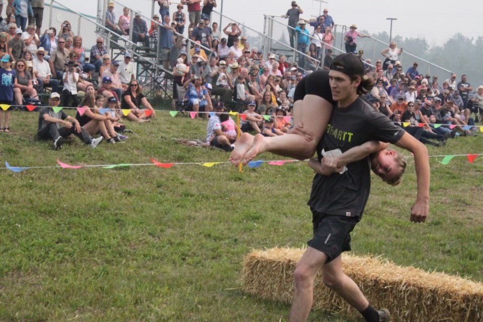On their way to victory. Hylo couple Cora Cummings and Reece Kingdon hear the cheers as they head toward a first-place finish at the recent Wife Carrying Races held at the Lakeland Country Fair in Lac La Biche. The races are the only sanctioned wife-carrying championships in Canada.