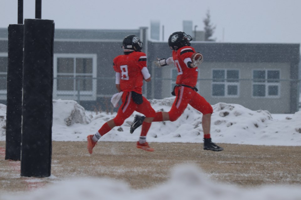 Ryan Songer (#8) runs with Luke Germain (#30) as the St. Paul Lions scores its first and winning touchdown.