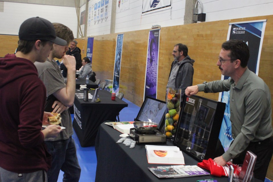 Jason Sachko, coordinator for the culinary program at Portage College, speaks with some attendees who stopped by his program booth. Chris McGarry photo.