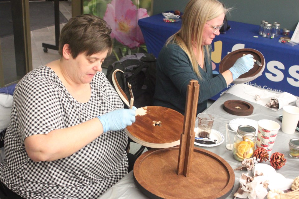 Tiffany Beniuk and Tammy Gordey work on their tiered serving trays at the most recent Crafting Connections session, which took place Tuesday at the Bold Centre. Chris McGarry photo.