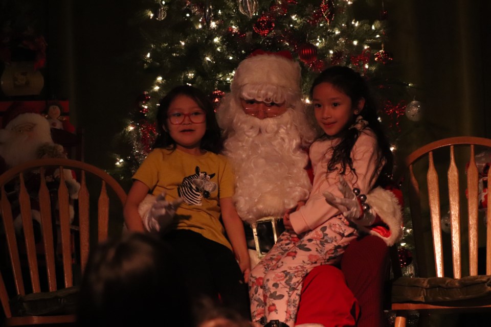 Santa Claus poses for a photo with children during the Mannawanis Native Friendship Centre Christmas Dinner on Dec. 9.
