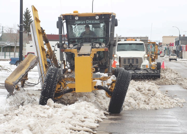 Graders clear slush and snow from 50th Avenue.