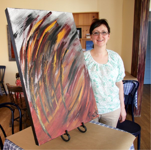Café Impromptu owner Pascale Proteau poses with RAGE, a painting she did as therapy for her own mental health.