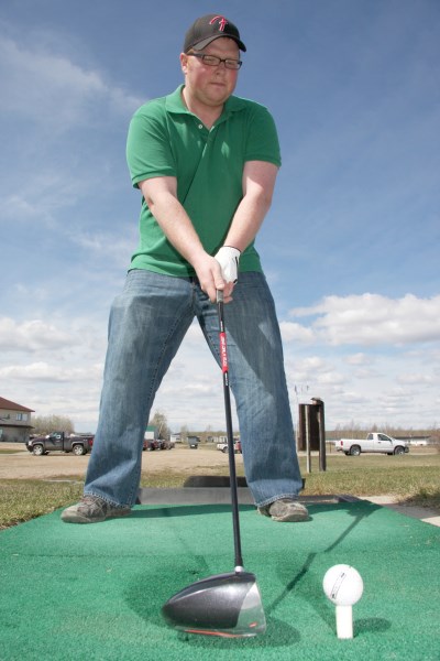 Tyler Caines of Red Deer lines up a shot at the Bonnyville Golf Club driving range on Sunday afternoon.