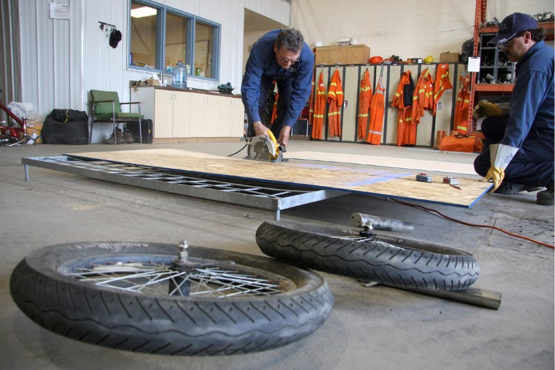 ATCO Electric bed builders Real Hebert, left, and Gord Zaboschuk work on constructing their team&#8217;s wheeled entry into the Great Bonnyville Bed Race.