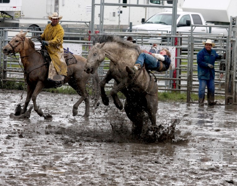 Novice bareback rider Gerard Oversby goes for a wild and muddy ride during Sunday&#8217;s Bonnyville Pro Rodeo performance.